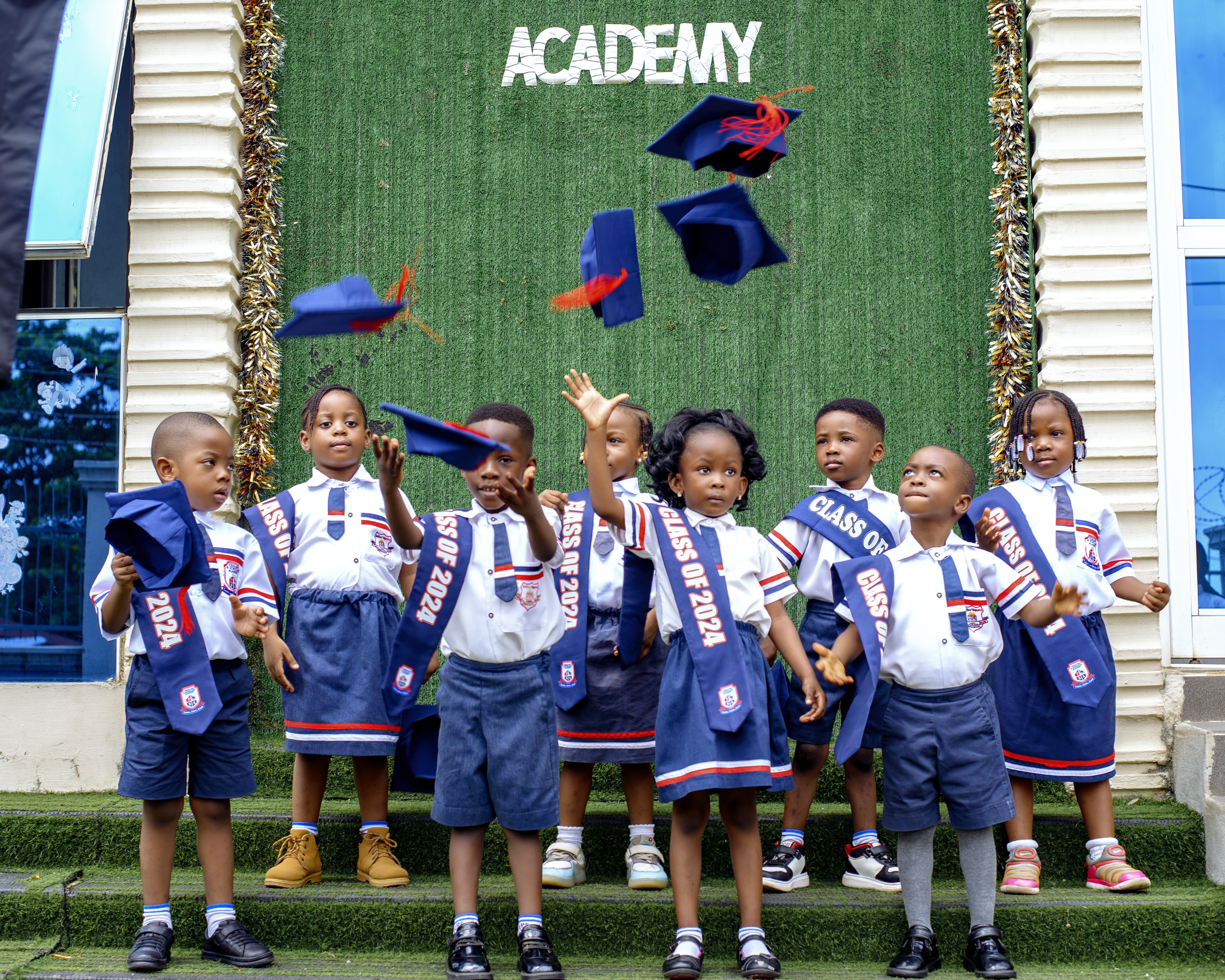 Graduates throwing caps outside the Academy