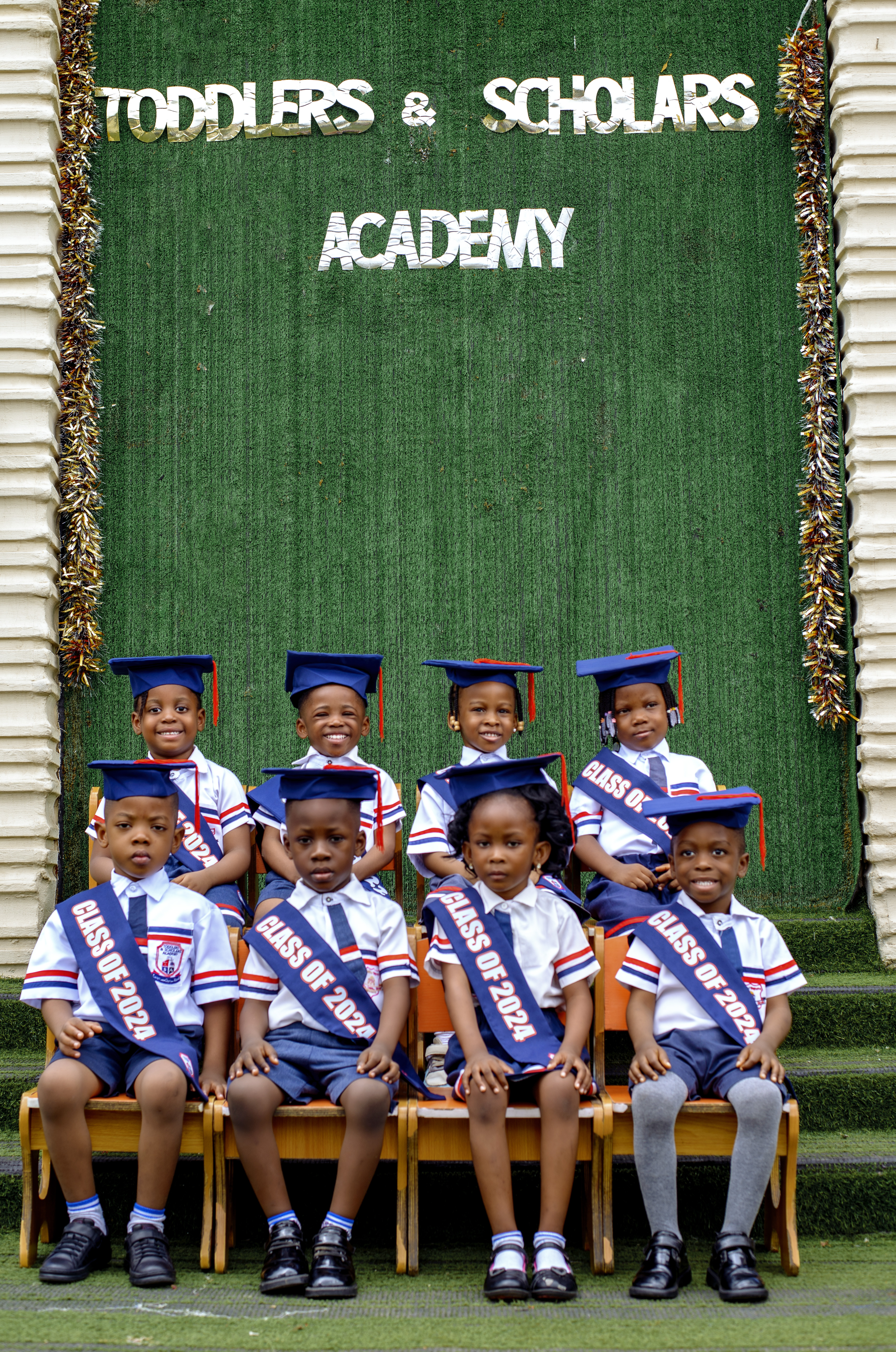 Class of 2024 in front of the Toddlers & Scholars Academy backdrop